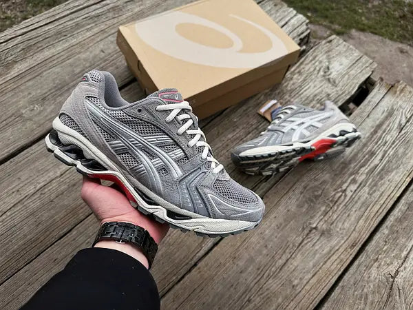 Sneaker vastgehouden in natuurlijk licht – zilveren lagen, mesh structuur en performance aesthetic perfect in beeld
