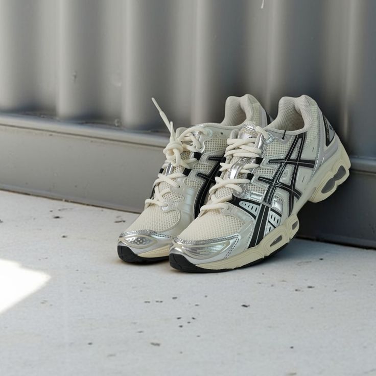 Close-up van de ASICS GEL-Nimbus 9 Cream Black 1201A424-101 met gelaagde mesh structuur, synthetische zwarte panelen en GEL-units