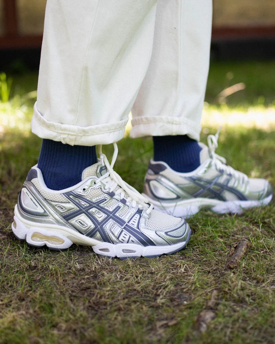 ASICS GEL-Nimbus 9 White Steel Grey 1201A424-102 in hand met reflecterende details, lichtgrijze panelen en zichtbare GEL-technologie