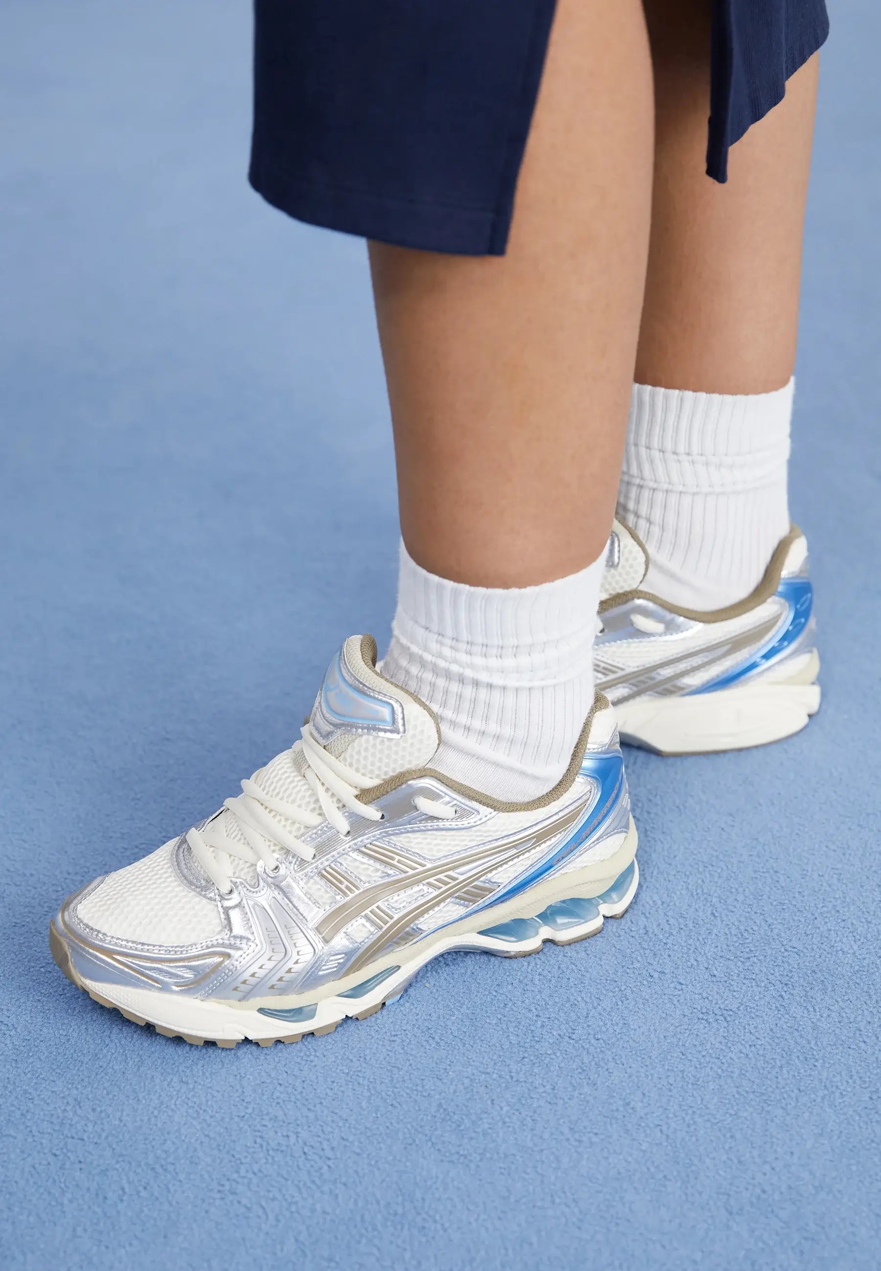 ASICS Cream Pepper gedragen met witte sokken en blauwe rok – stijlvol contrast voor een vrouwelijke retro look