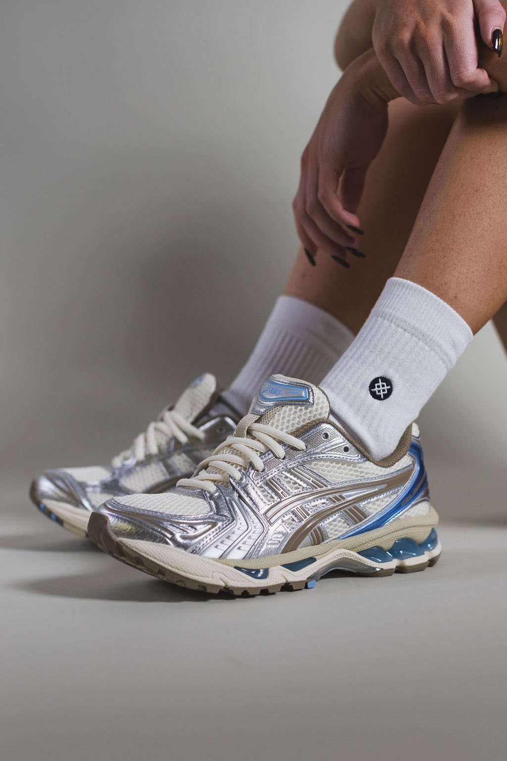 On feet shot van de ASICS Gel Kayano 14 Cream Pepper met subtiele shine en zachte demping – perfecte mix van sport en stijl