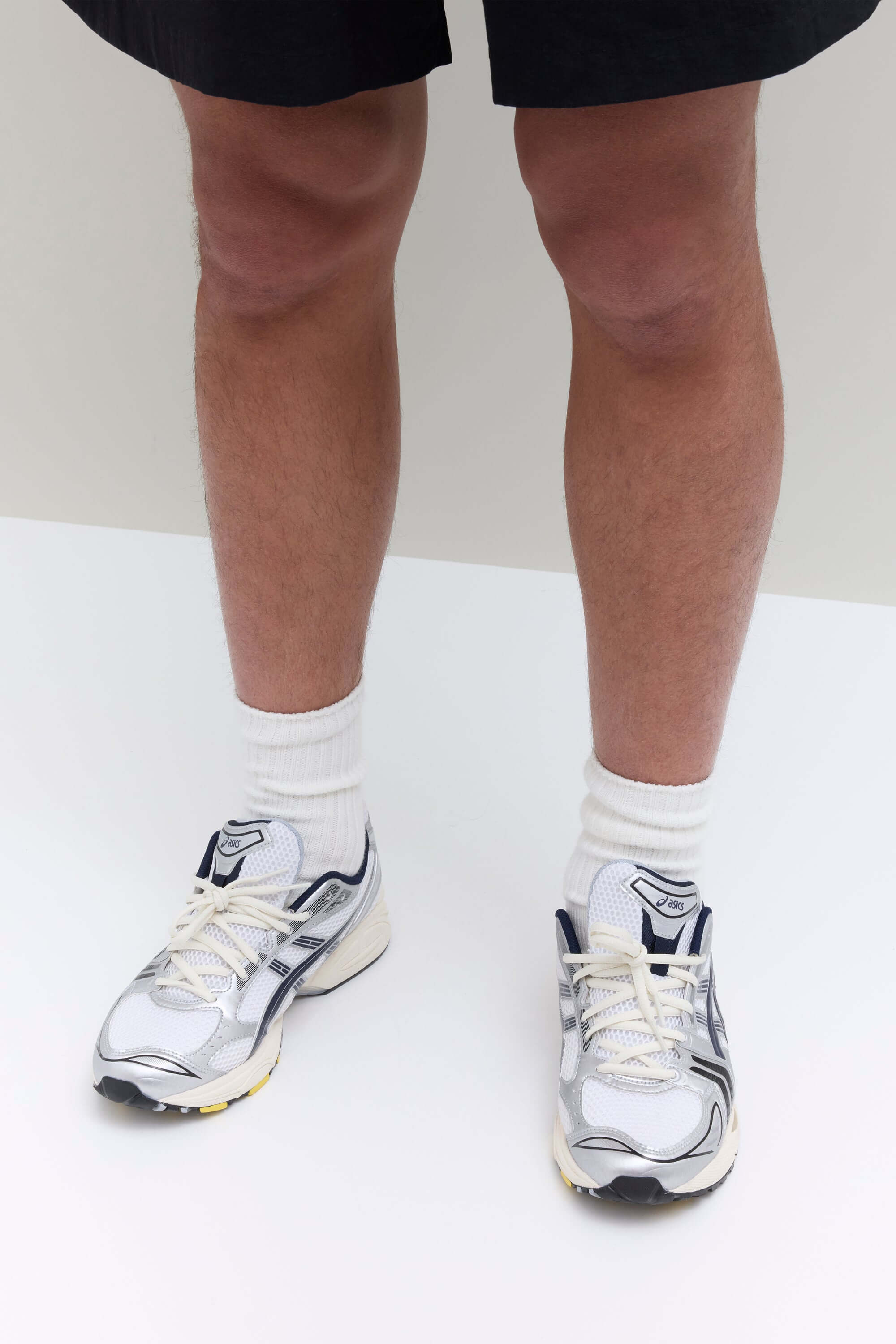 Bovenaanzicht van de sneaker met JJJJound-logo op de tong, strak vetersysteem en mesh overlays in wit en donkerblauw