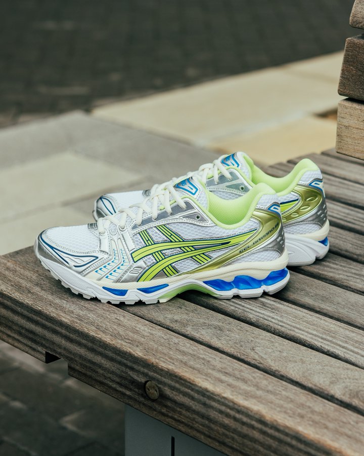 Sneaker in de hand gehouden bij natuurlijk licht – limegroen en zilver springen eruit op het retro hardloopdesign