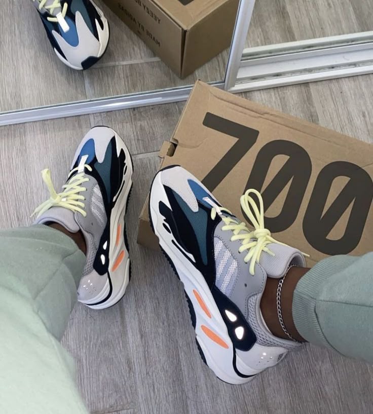 Adidas Yeezy 700 Wave Runner B75571 half in de originele 700 doos geplaatst, waarbij de retro kleurencombinatie naar voren komt