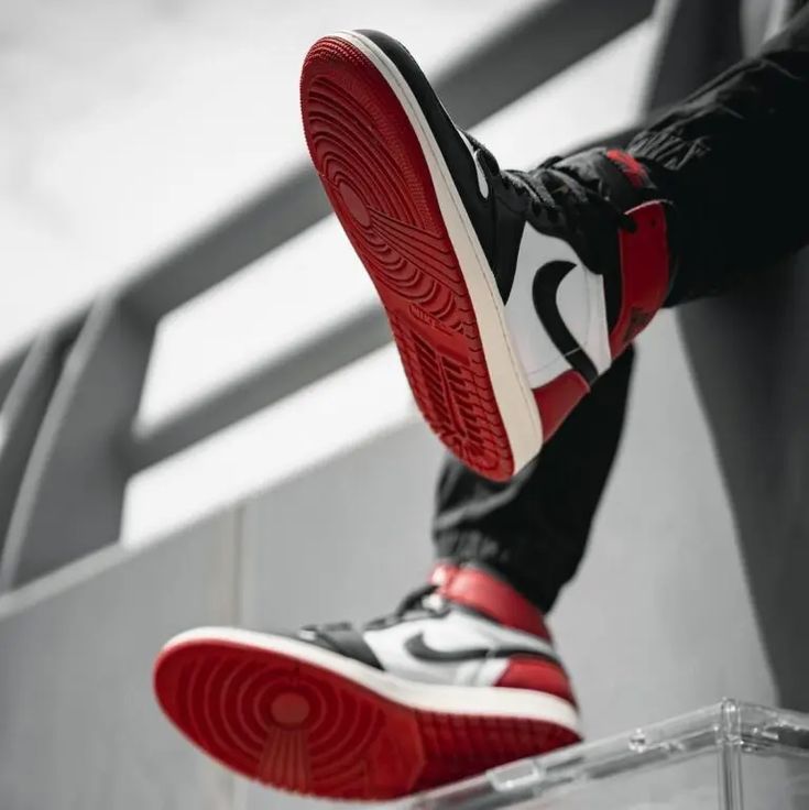 Jordan 1 Black Toe Reimagined on feet gezien van onderen met zicht op rode outsole – klassieke gripzool en heritage look