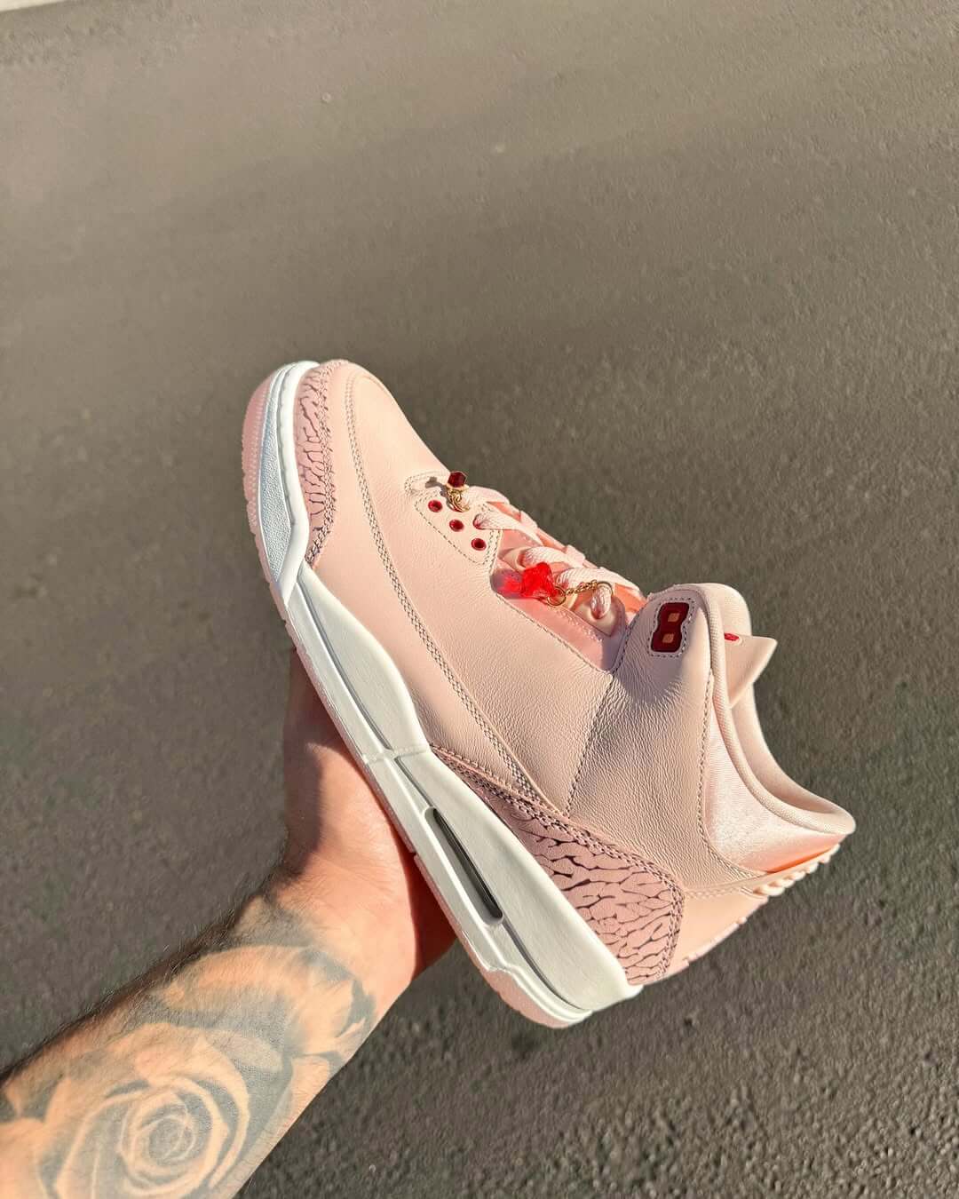 Close-up van Air Jordan 3 Retro Valentine's Day Treat Yourself met geborduurde Jumpman, rode binnenvoering en premium elephant print