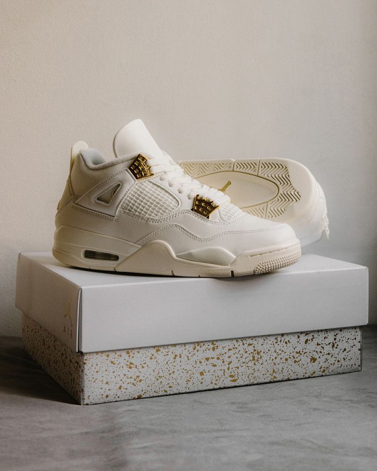 Sneaker geplaatst op de originele doos met goudkleurige Jumpman, perfect voor sneakercollectors.