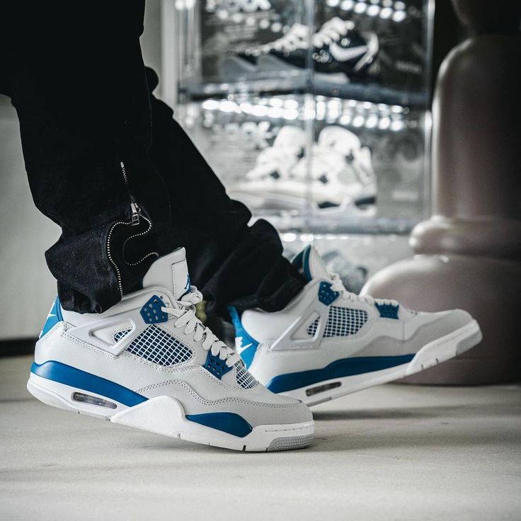 Air Jordan 4 Retro Military Blue gedragen hoge sneaker met witte basis en blauwe details close-up