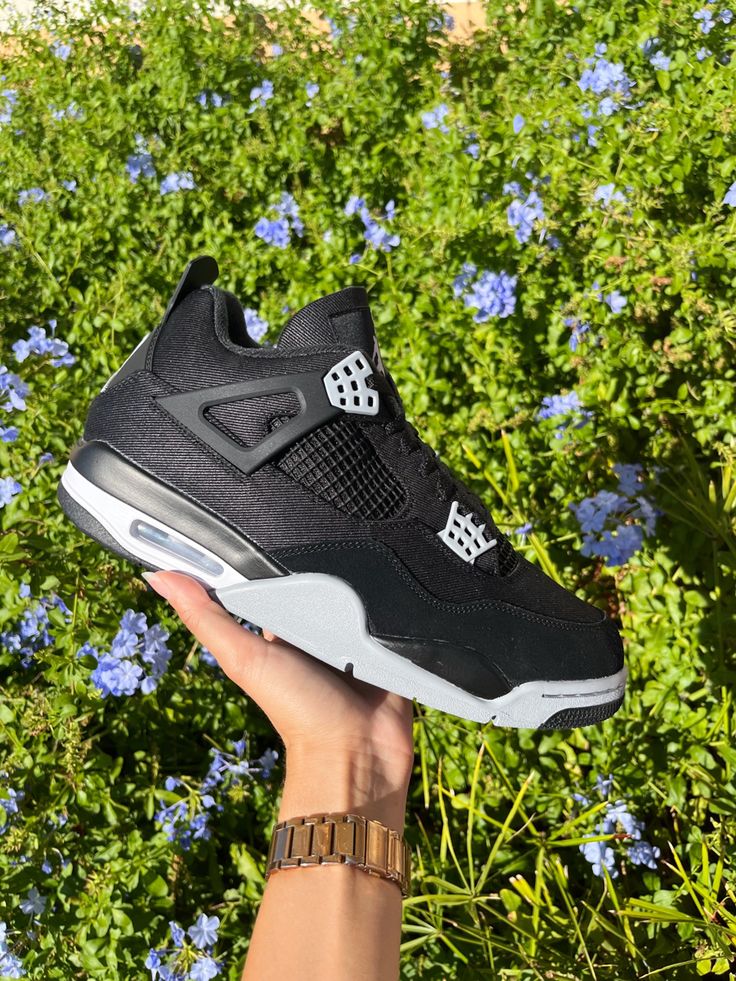 Zwarte hoge Nike Air Jordan 4 schoen met lichtgrijze details.