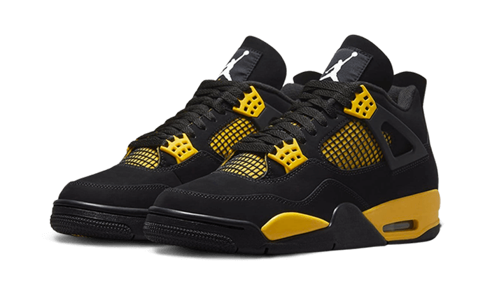 Close-up van de Air Jordan 4 Thunder met zwarte upper, gele veterhouders en stevige zwarte zool met contrastdetails.