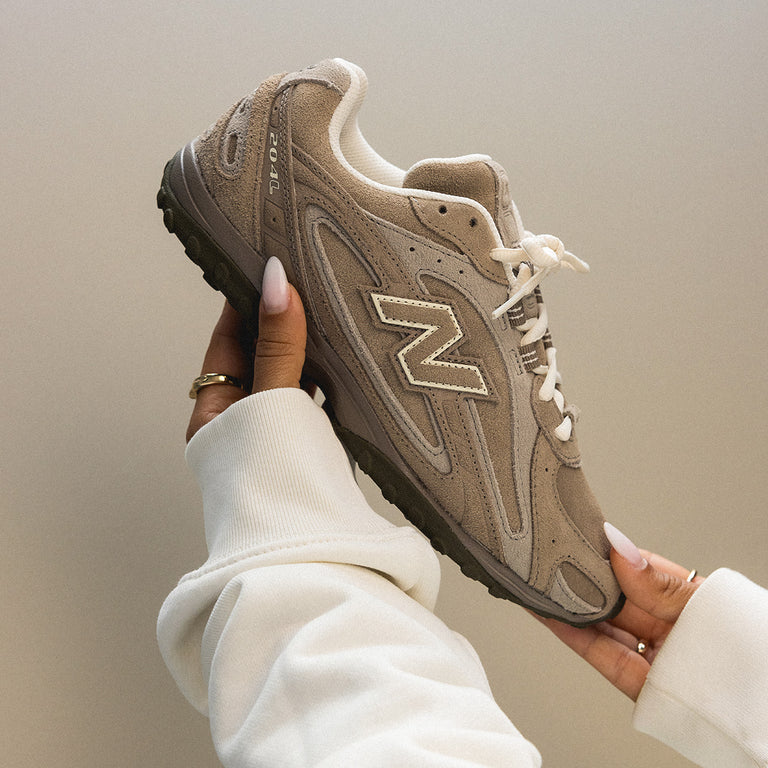 Close-up van de New Balance 2004L Mushroom Arid Stone met gewatteerde kraag, robuuste loopzool en kenmerkende N-logo