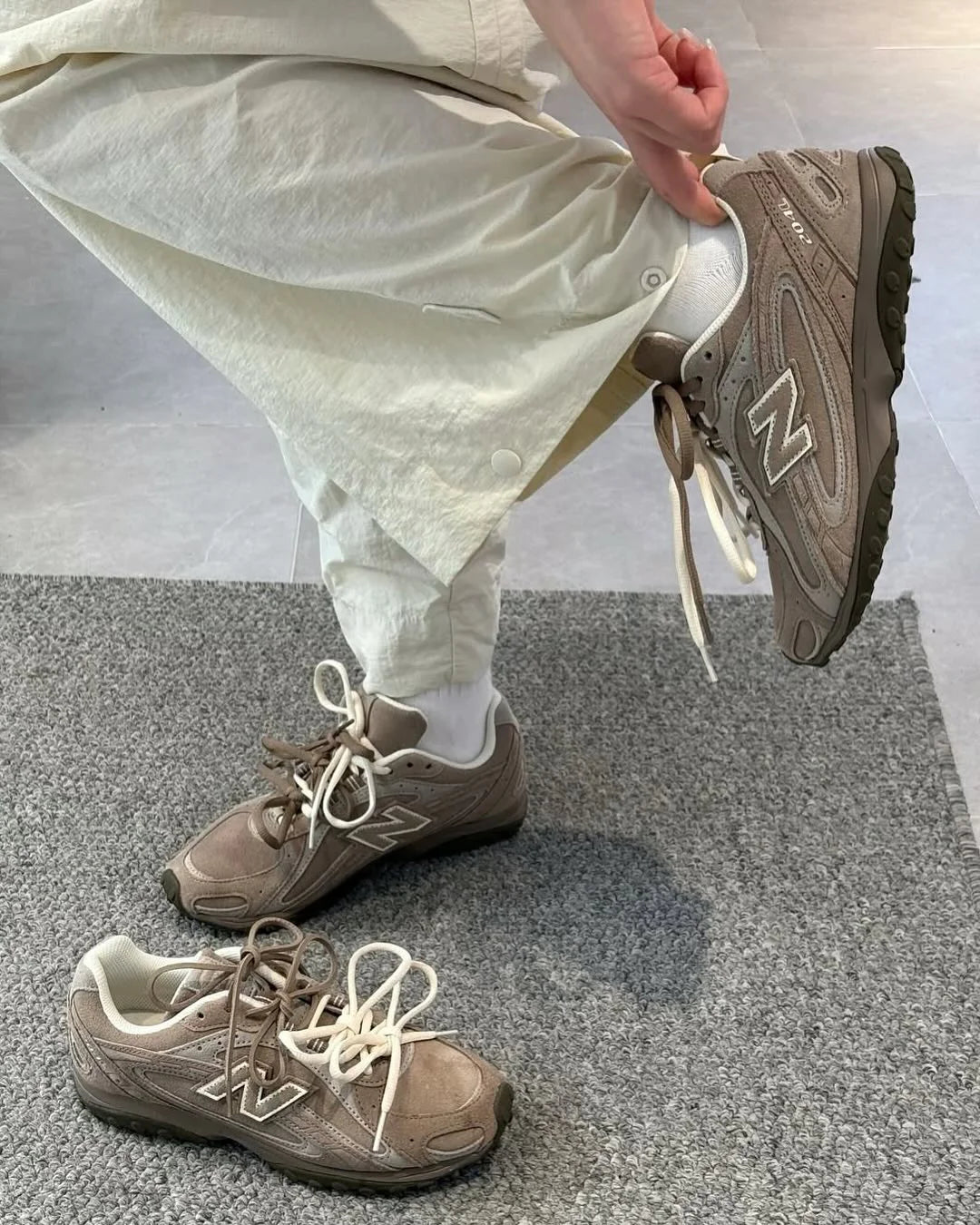 New Balance 2004L Mushroom Arid Stone on-feet gecombineerd met een beige cargobroek voor een outdoor streetwear look