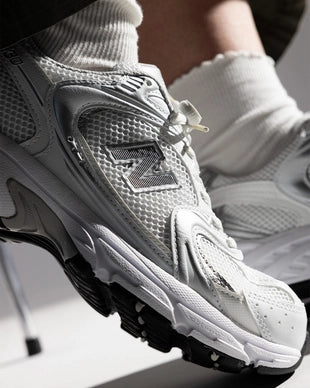 Bovenaanzicht van de New Balance 530 Munsell White met ademend mesh, subtiele branding en witte veters