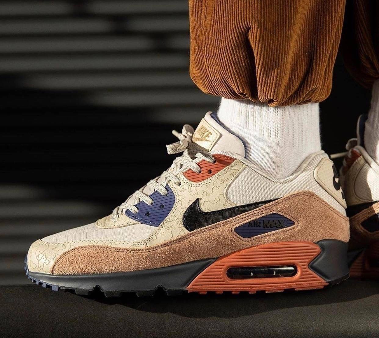 Achteraanzicht van de Camowabb met zicht op zwarte hielstructuur, camouflage sidepanels en gespikkelde midsole – outdoor vibes in iconisch Air Max 90 frame