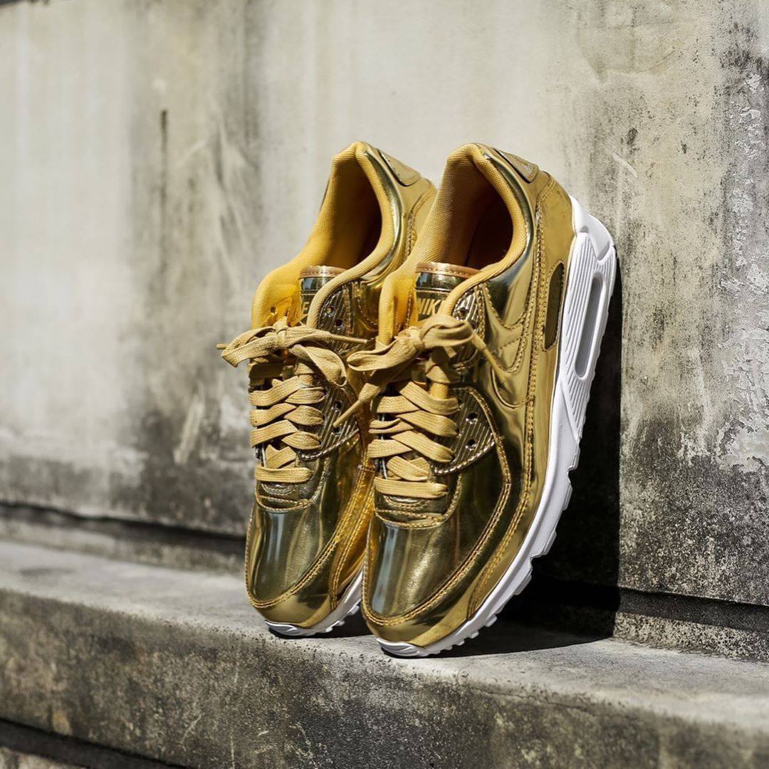Achteraanzicht van de Air Max 90 met zicht op goudkleurige hielstructuur, Nike Air logo en witte demping – glanzend en OG tegelijk