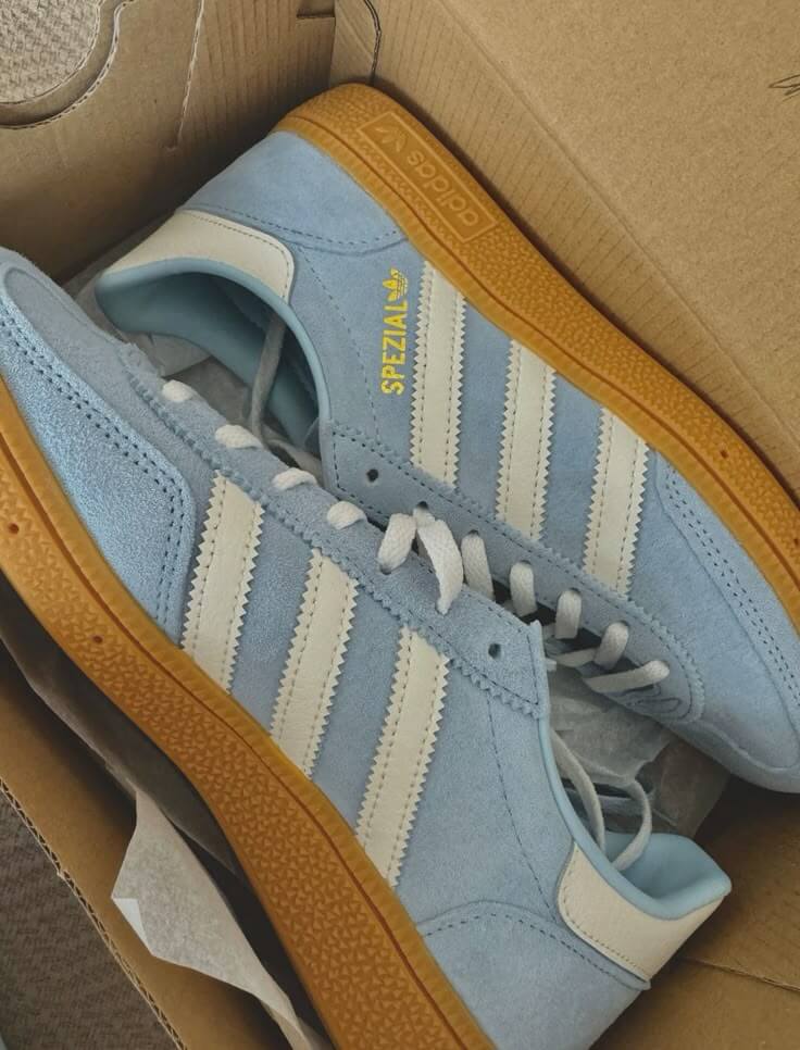 Adidas Handball Spezial Clear Sky (Women's) – close-up van het zachte Clear Sky suède, goudkleurig Spezial-logo en frisse witte leerdetails
