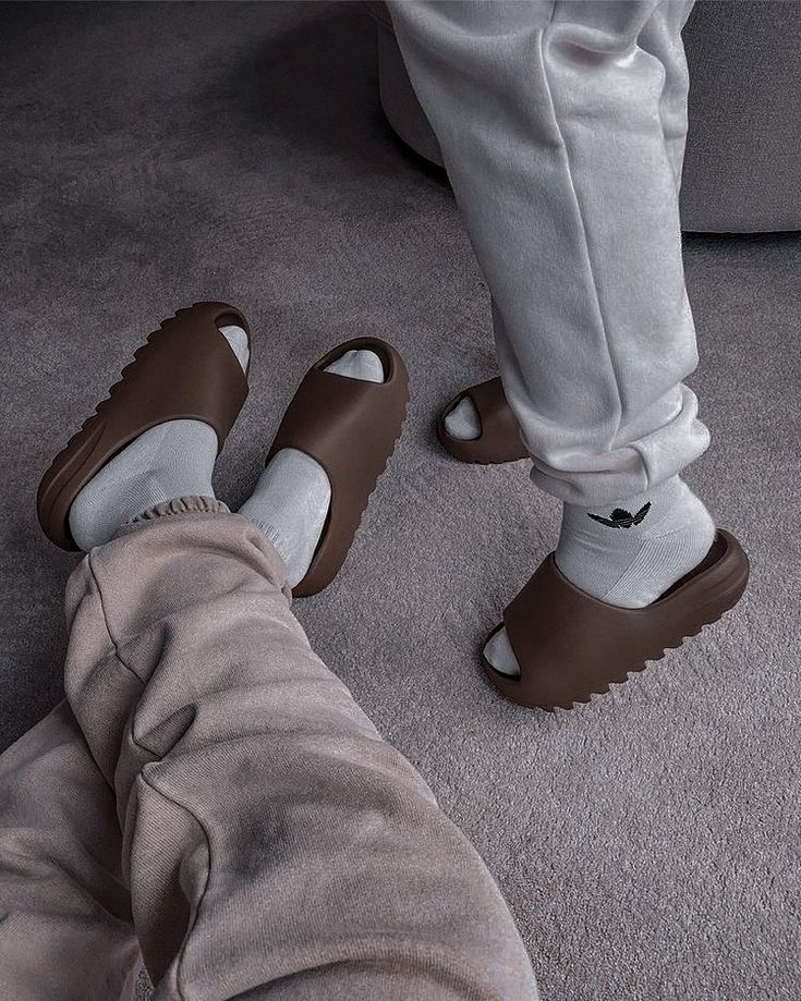 In-hand shot van Yeezy Slide Flax FZ5896 – bruin-beige EVA body met diepe zoolstructuur en clean silhouet in daglicht