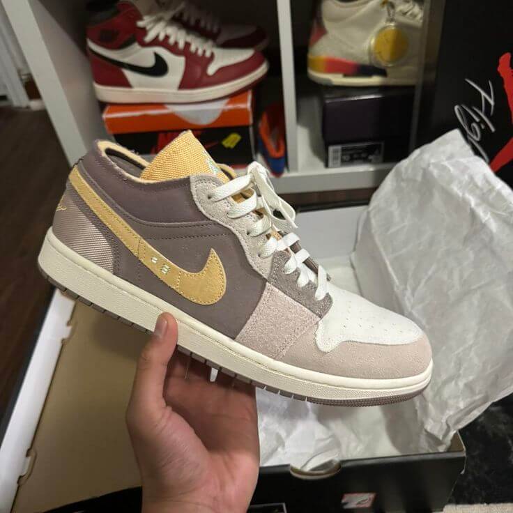 Air Jordan 1 Low SE Craft Inside Out (SKU DN1635‑100) – in‑hand shot met zicht op nubuck textuur, exposed tongue en tongue-tag