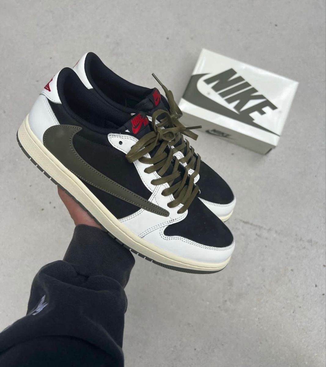 Air Jordan 1 Low OG Travis Scott Olive (SKU DZ4137‑106) – in-hand shot met zicht op reversed Swoosh, Cactus Jack hiel-logo en olive outsole
