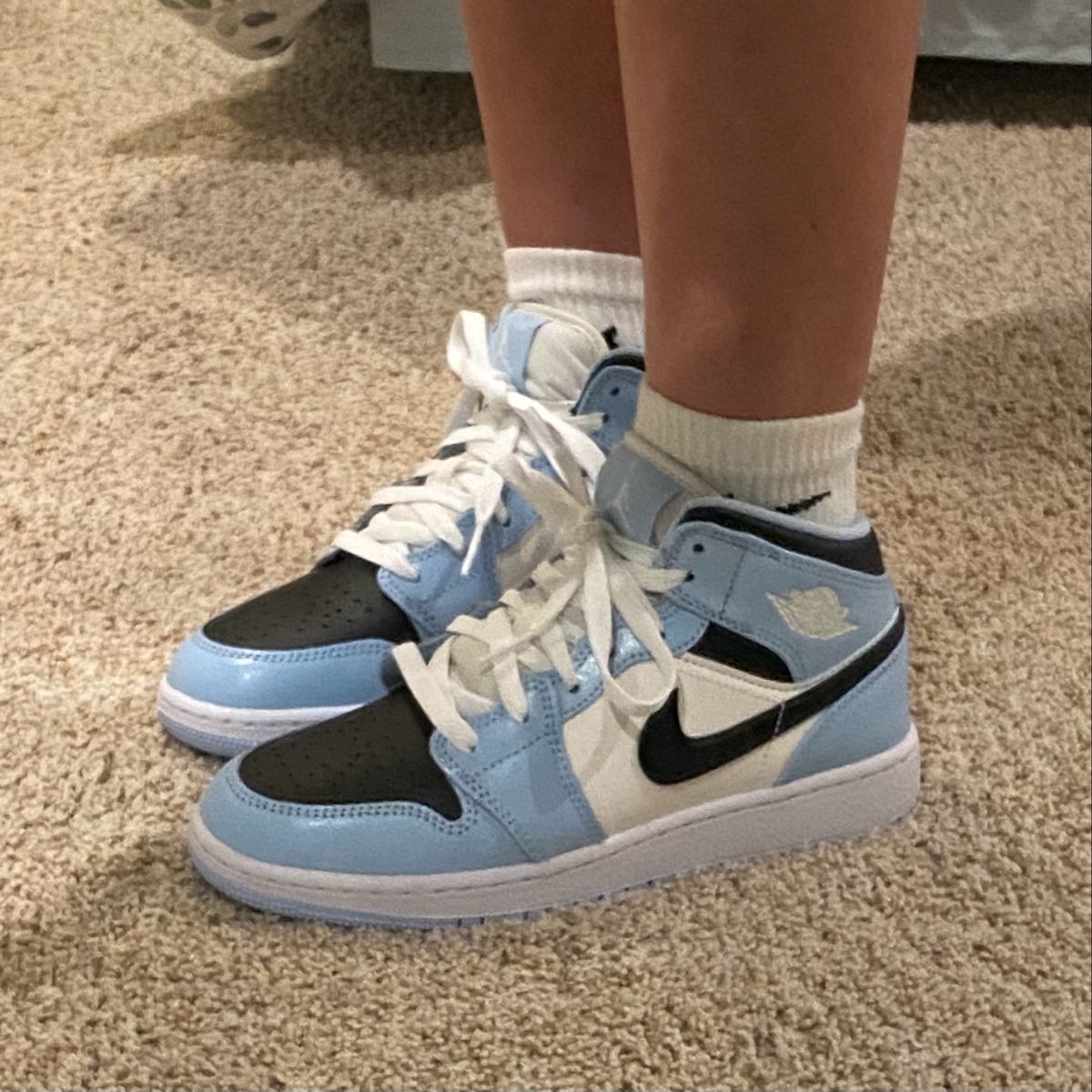 Close-up van lederen textuur rond toebox, Swoosh en hiel – ice blue leer gecombineerd met zwart stiksel en witte zoo