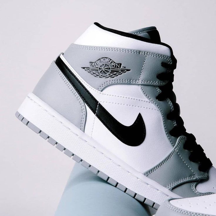 Meerdere paren Jordan 1 Mid Light Smoke Grey gestapeld – klassieke kleurencombinatie in wit, grijs en zwart voor minimal outfits