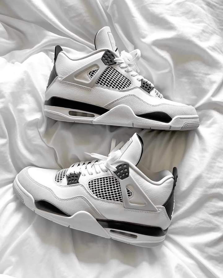 DH6927-111 half uit de cementdoos geschoven, met zicht op het Jumpman-logo, witte tongstructuur en zwarte branding tegen zachte ondergrond