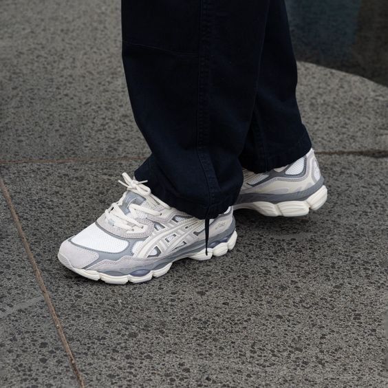 Bovenaanzicht van de ASICS GEL-NYC Cream Oyster Grey – zicht op tonglogo, veters en kleurverdeling in neutrale tinten via Snrkickz