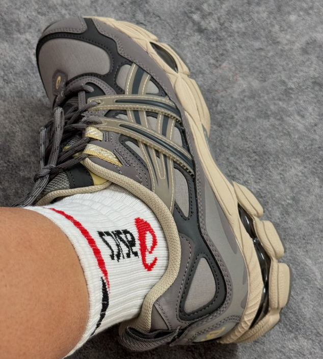 Bovenaanzicht van de ASICS GEL-NYC Utility Steeple Grey – zicht op tonglogo, veters en grijze layered paneling via Snrkickz