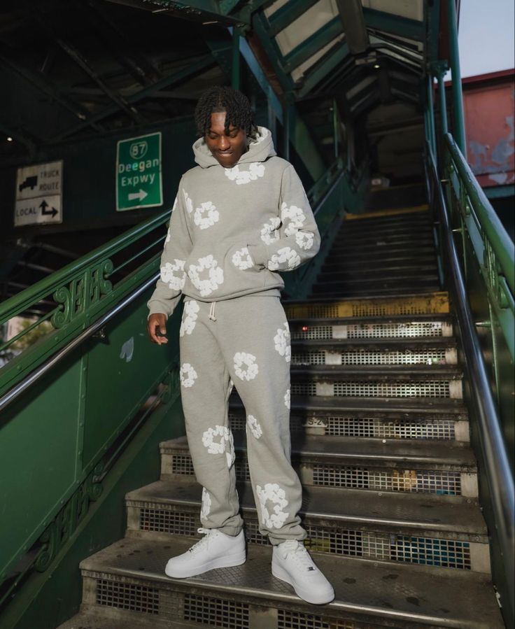 Denim Tears The Cotton Wreath Sweatpants Grey – model draagt relaxed fit sweatpants in urban styling met sneakers