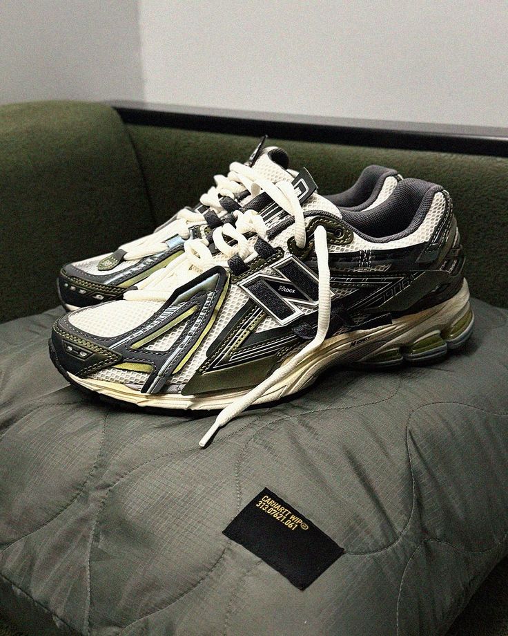 In-hand view van de New Balance 1906A in Olive Juice en Sea Salt. De aardse kleuren en functionele esthetiek maken deze release perfect voor liefhebbers van subtiele maar uitgesproken sneakers.