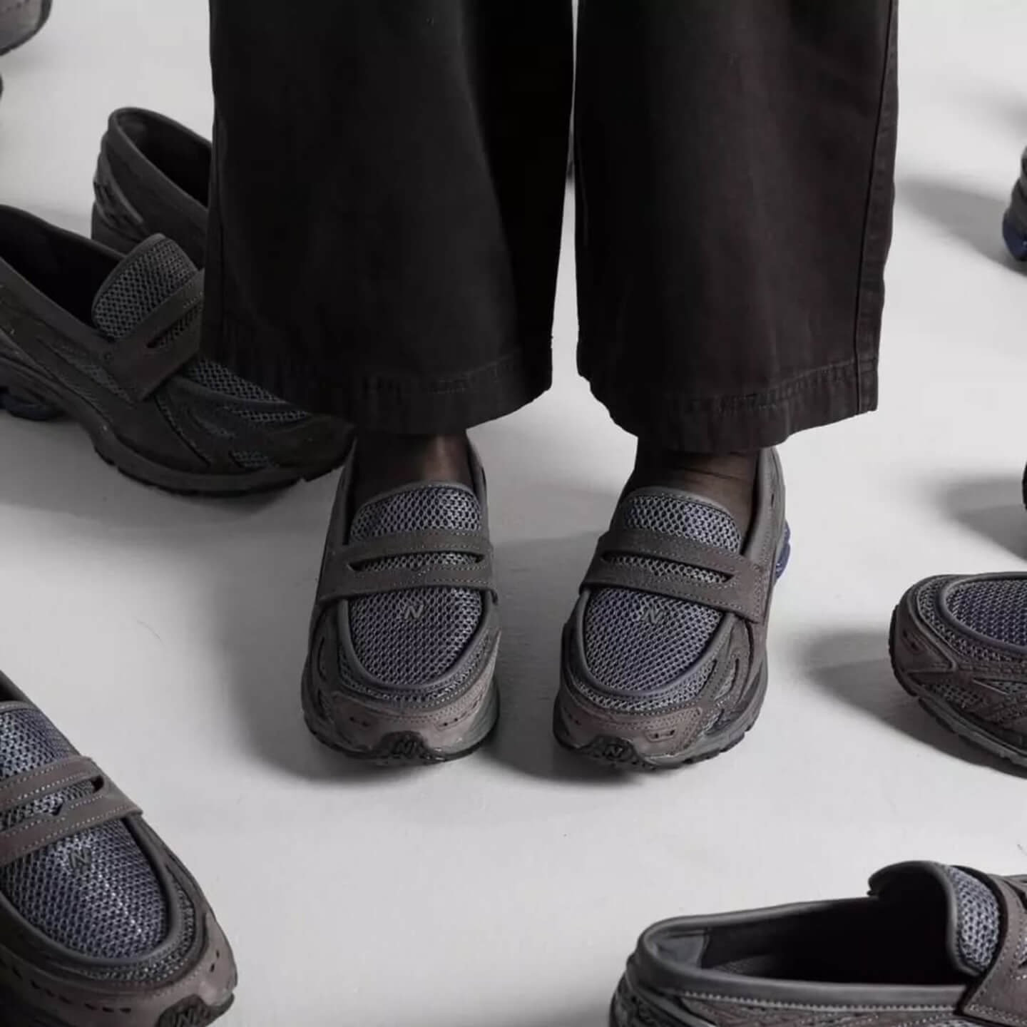 In-hand view van de New Balance 1906L in Magnet kleurstelling. De subtiele glans en het donkere palet maken dit tot een veelzijdige en tijdloze lifestyle runner.