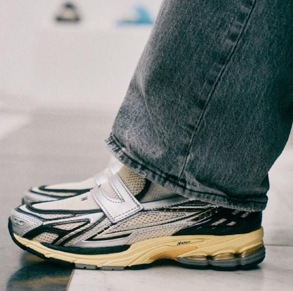 In-hand view van de New Balance 1906L in Silver Metallic met Cream details. Deze opvallende colorway combineert performance met esthetiek en is een echte eyecatcher in de 1906-serie.