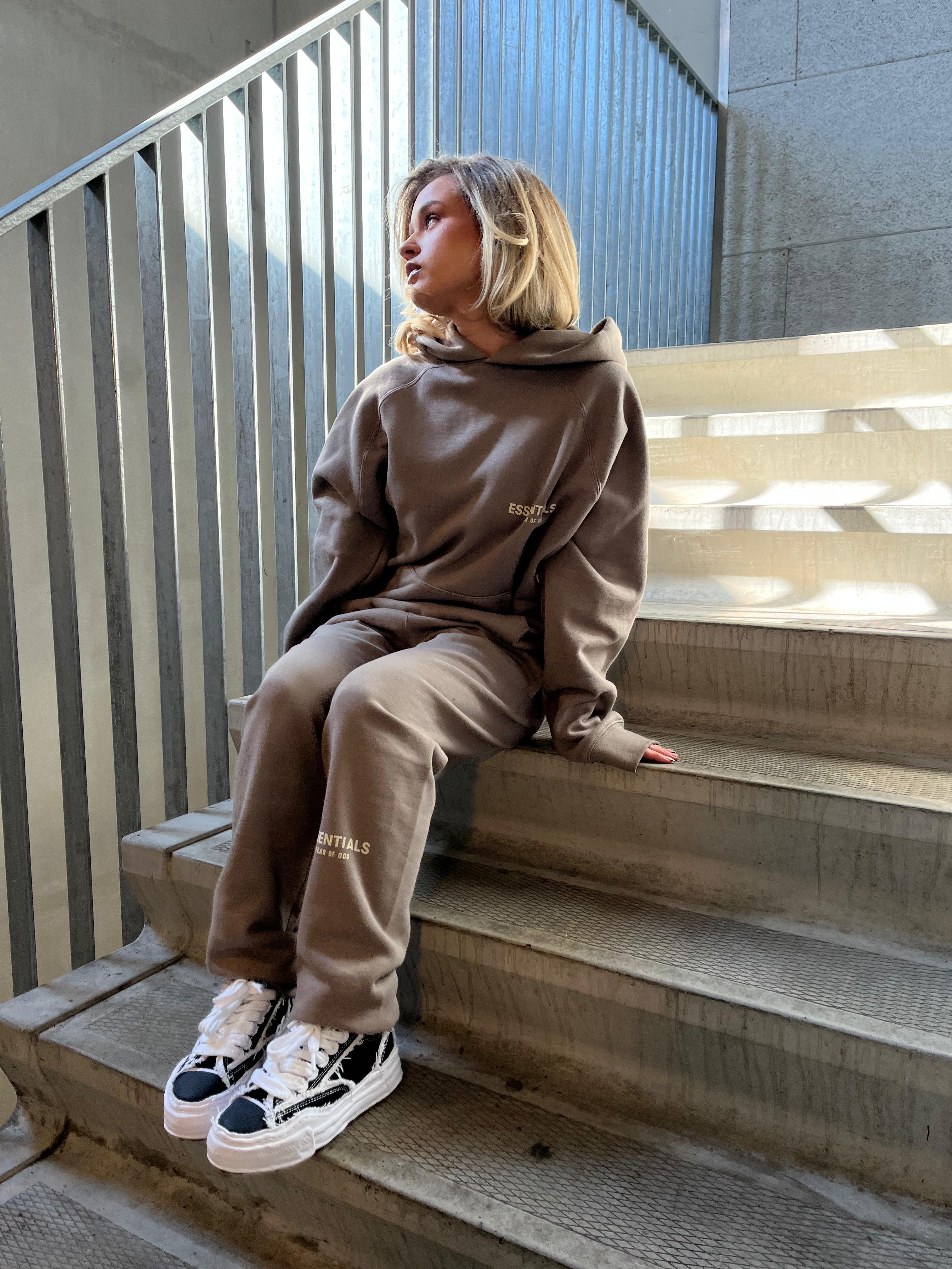 Essentials Desert Taupe tracksuit met beige two-piece en Mihara OG Sole Frayed Black sneakers zittend op trap, clean en edgy