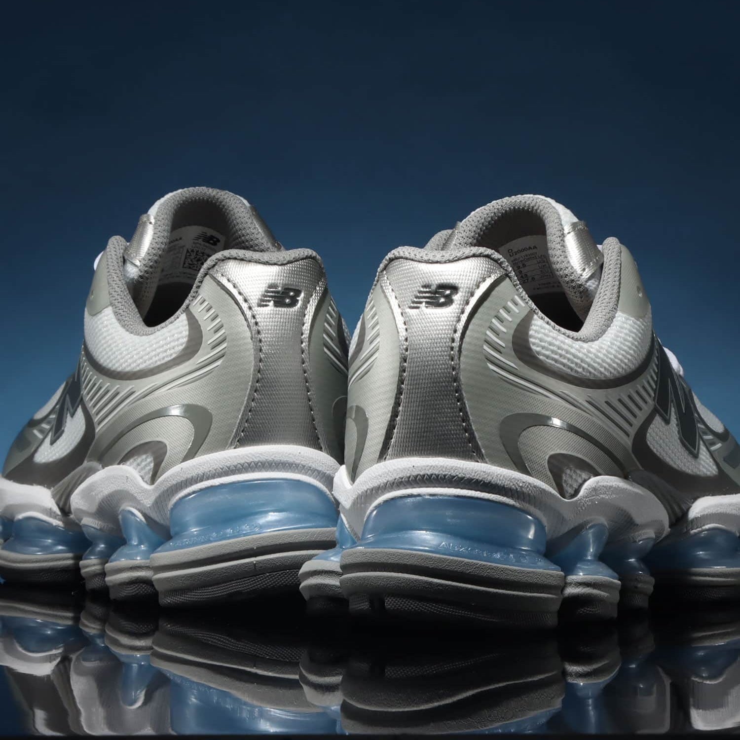 New Balance ABZORB 2000 White/Grey‑Blue – in‑hand shot van sneaker (~420 g) met zicht op mesh upper, metallic overlay en ABZORB midsole