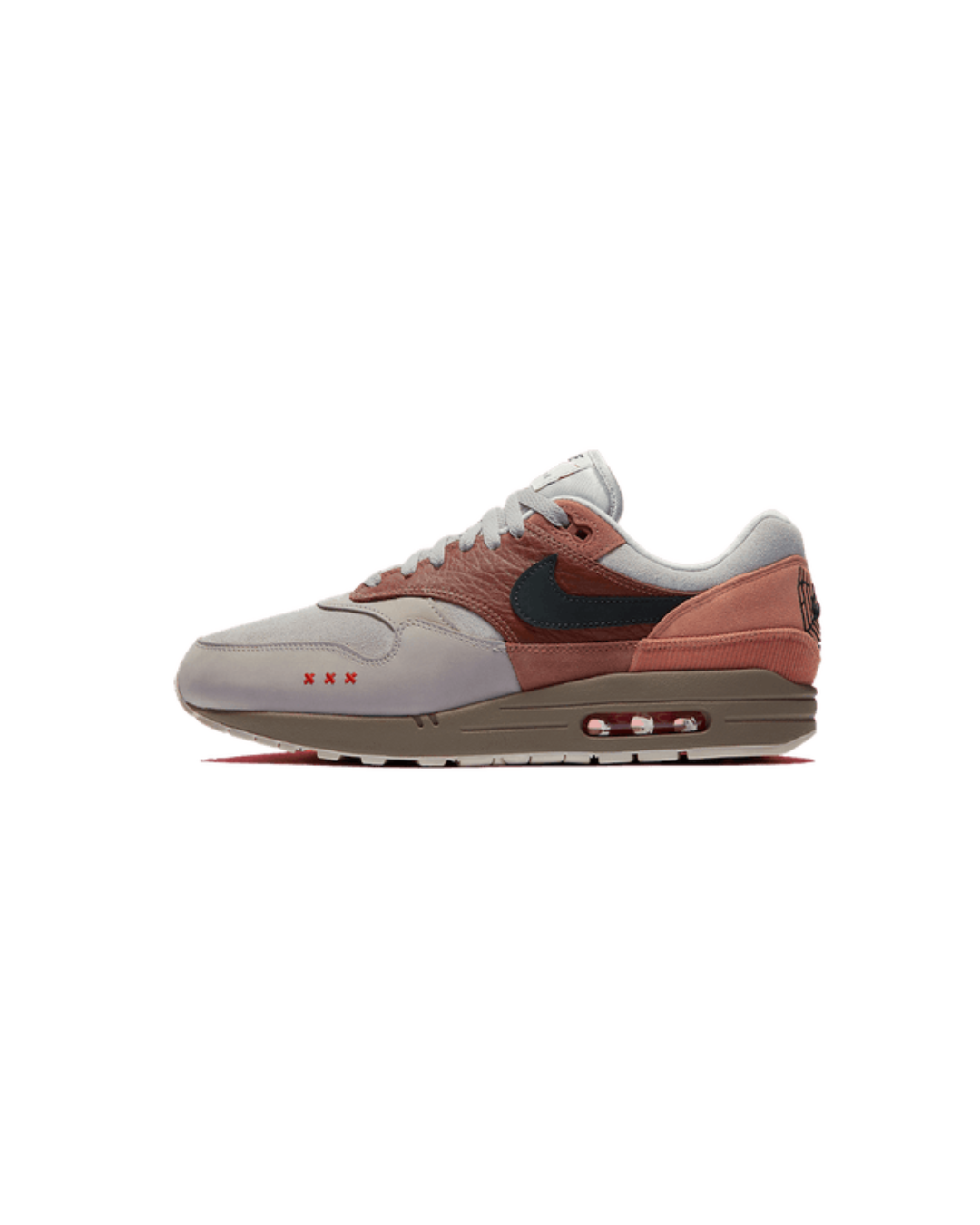 Zijaanzicht van de Air Max 1 Amsterdam met baksteenrode tinten, suède overlays en een minimalistische, cleane achtergrond die het silhouet versterkt