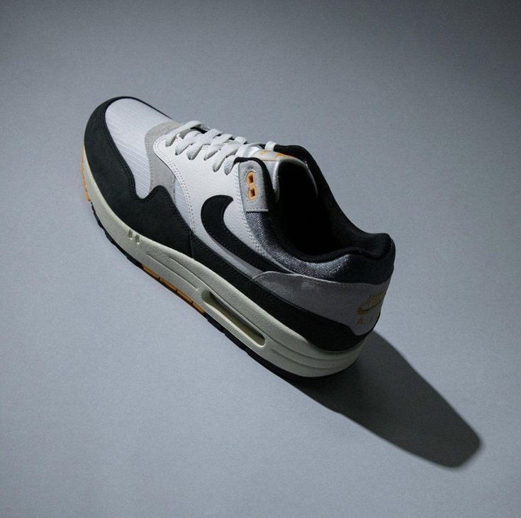 Detail van de Nike Air Max 1 Athletic Department – suède overlay, stitched logo en textuur close-up via Snrkickz