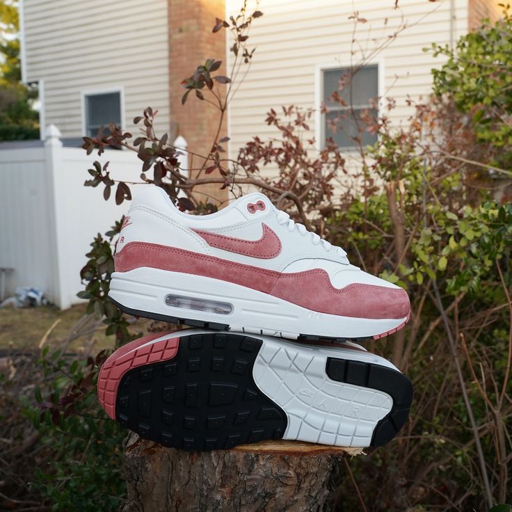 In scène gezette outdoorfoto met model op tuinmuur, sneaker valt op door het zachte kleurenpalet en streetwear vibe