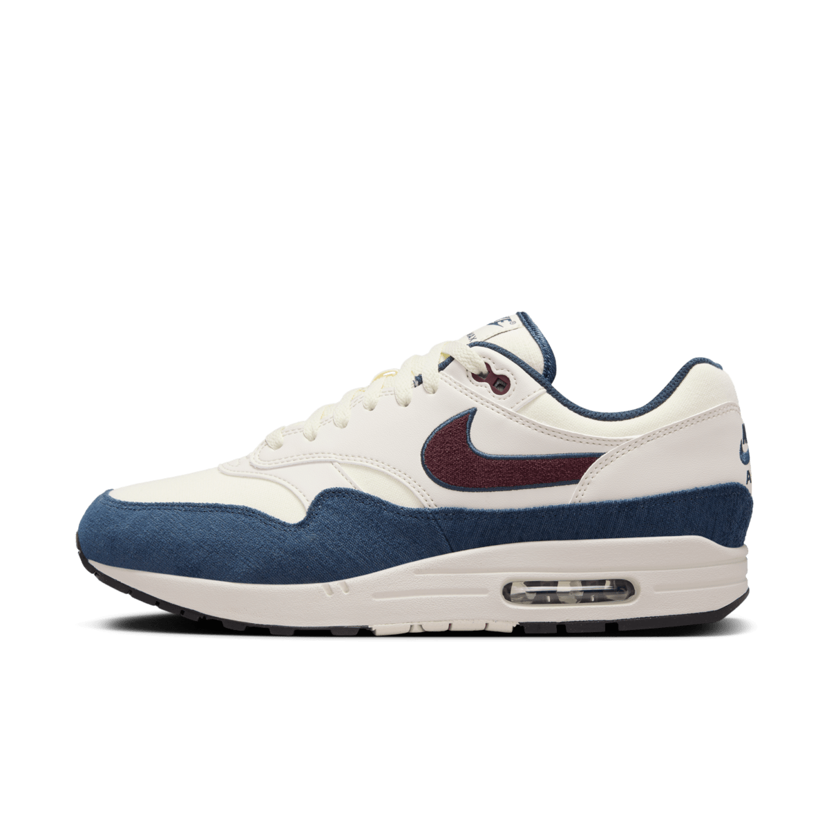 Zijaanzicht van de Nike Air Max 1 Coconut Milk met burgundy swoosh, navy mudguard en offwhite suède overlays