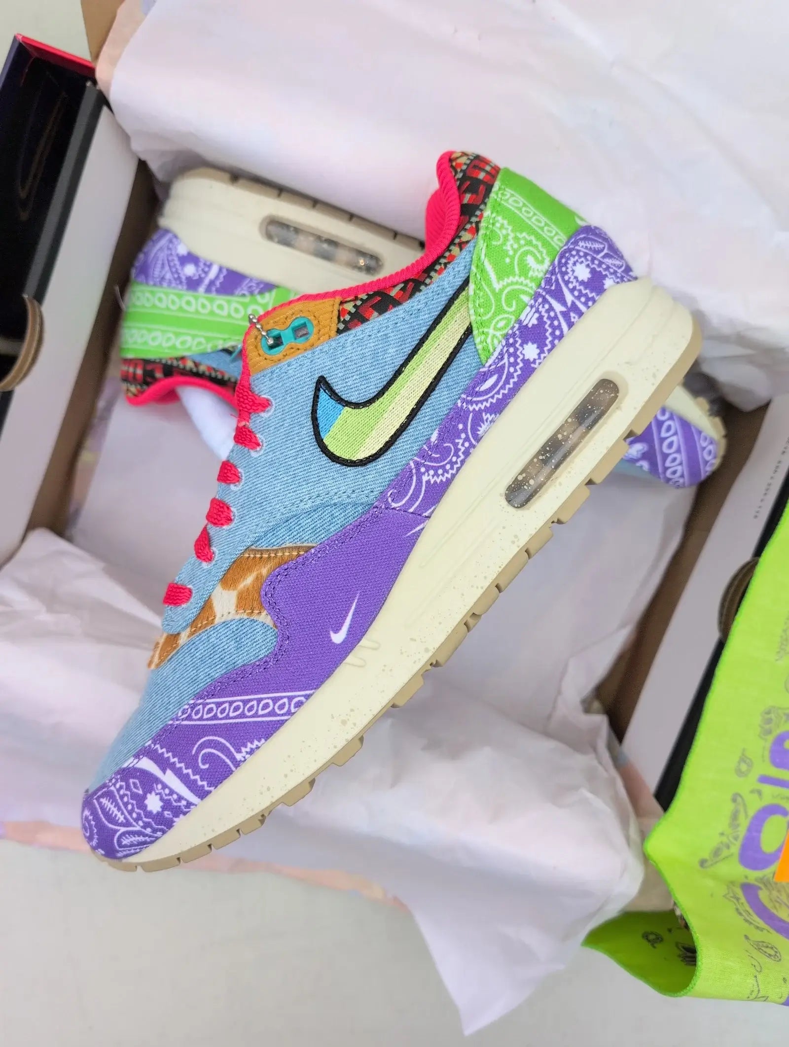 Floating beeld van de Air Max 1 Far Out boven originele verpakking, met focus op texturen, kleuren en retro vibes