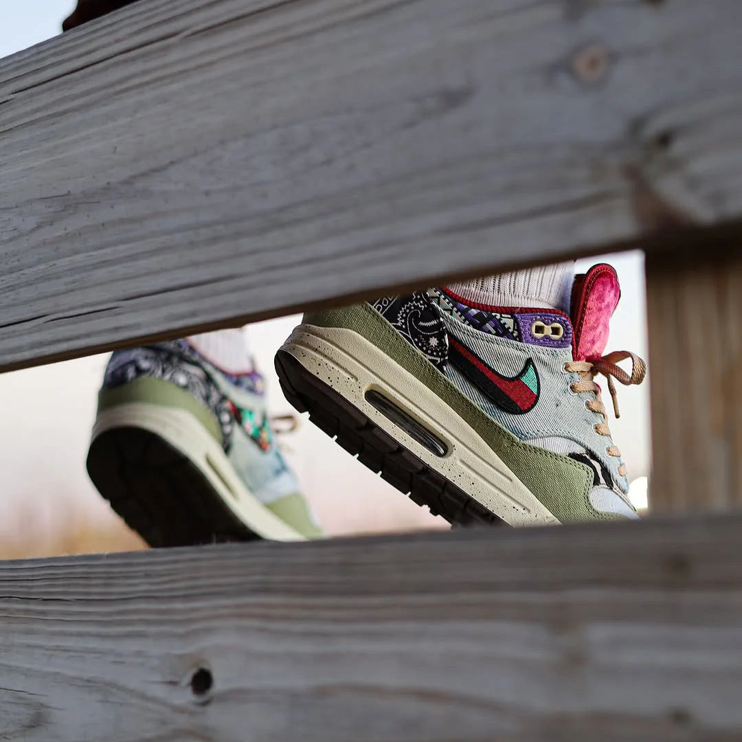 Gestileerd trapshot met beide sneakers gedragen op houten balken, waarbij de creatieve colorblocking en buitengevoel worden versterkt
