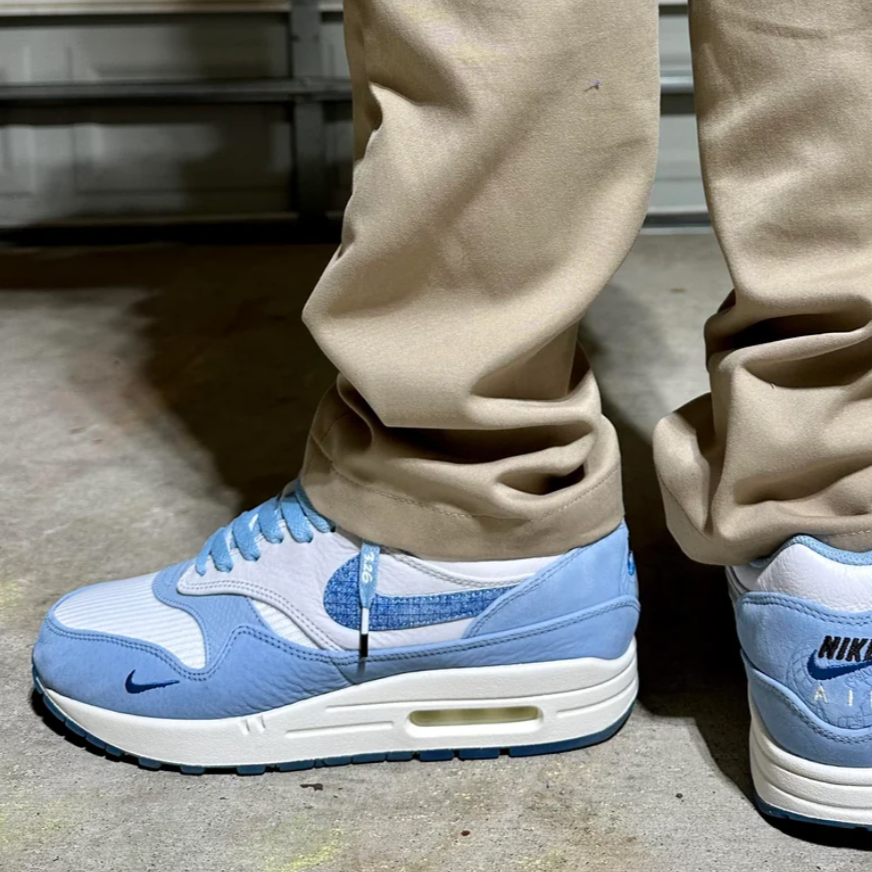 Hielshot van de Nike Air Max 1 Blueprint gedragen met sokken, blauwe Swoosh en blueprint-logo op de hiel – gefotografeerd vanuit een lage hoek