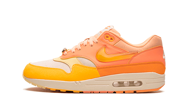 Zijaanzicht van de kleurrijke Nike Air Max 1 Orange Frost, met een mix van feloranje en pastelgeel leer op een off-white zool