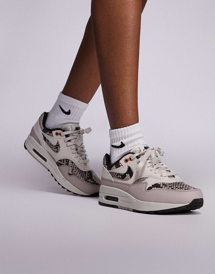 Model draagt de sneaker met hoge sokken; kleurstelling komt helder naar voren tegen neutrale outfit en vloerreflectie