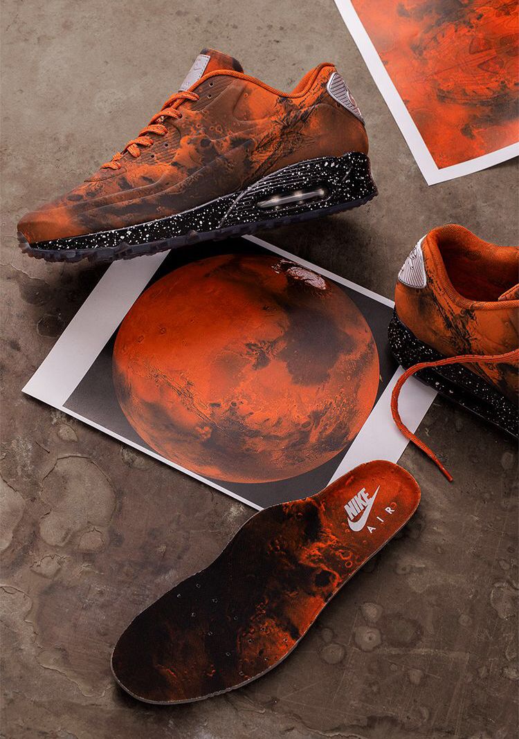 In hand shot van de Nike AM90 Mars Landing met glanzend oppervlak, all-over Marsgrafiek en zichtbare Air-unit