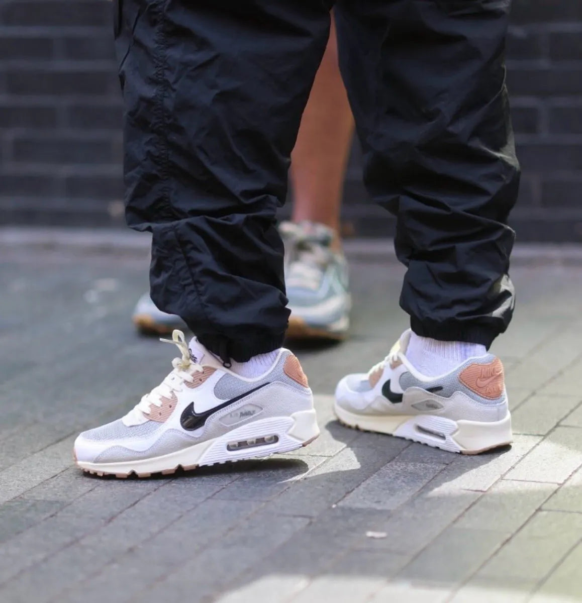 On-feet shot met zwarte cargo-broek en witte sokken, waarin de colorway tot leven komt op straatstenen