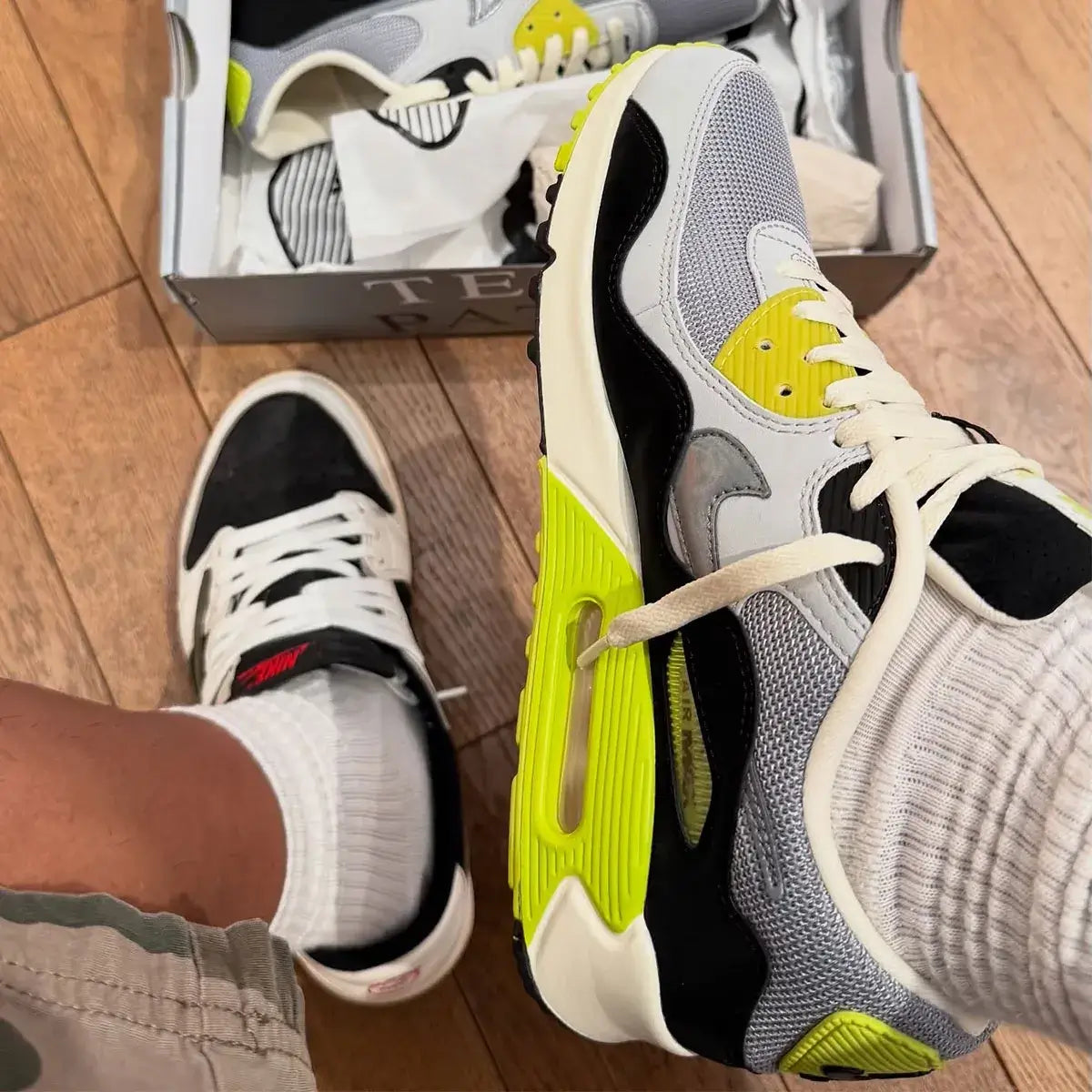 In hand shot van de Patta x Nike AM90 Waves Cyber met premium materialen, zichtbare Air-unit en felle kleuraccenten