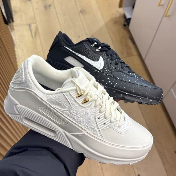 Topdown van de Air Max 90 Slawn met zwart bovenwerk, gekleurde tonglabel en opvallende grafische details