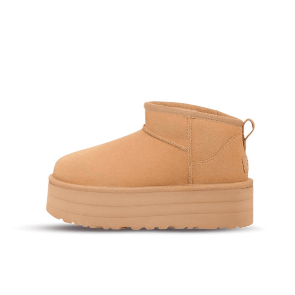 Zijkant van de UGG Classic Ultra Mini Platform Driftwood op zachte beige ondergrond, met focus op de robuuste plateauzool en warme kleurtonen