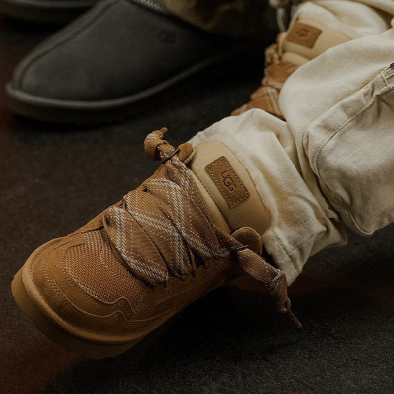 De UGG Lowmel Chestnut gedragen met beige sweatpants in een ontspannen streetwear-setting