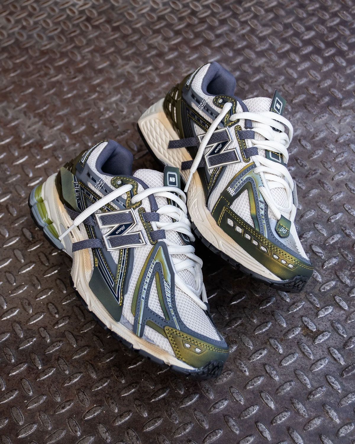 Onderkant van de New Balance 1906A met gripvaste zool in Sea Salt en Olive Juice tonen. De zool biedt demping en stabiliteit voor dagelijks comfort in een stijlvol outdoor-inspired design.